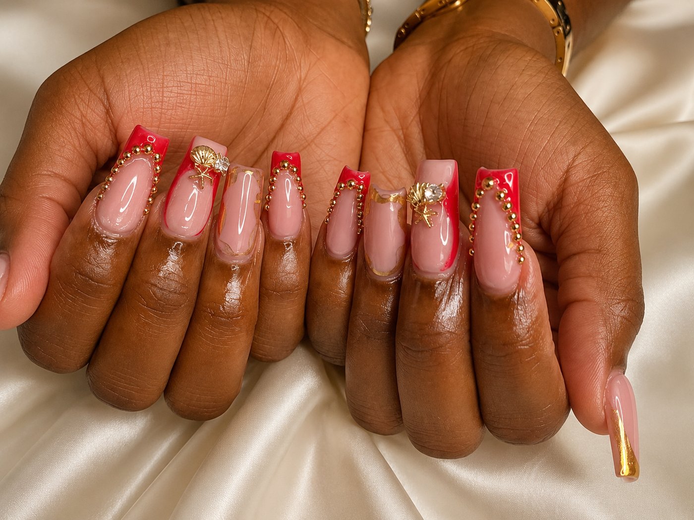 Gold French tip acrylic nails resting on cream linen in morning light